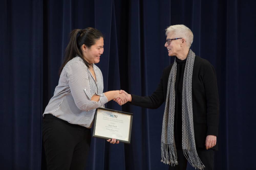 GSA President shaking hands with and presenting award to a professor